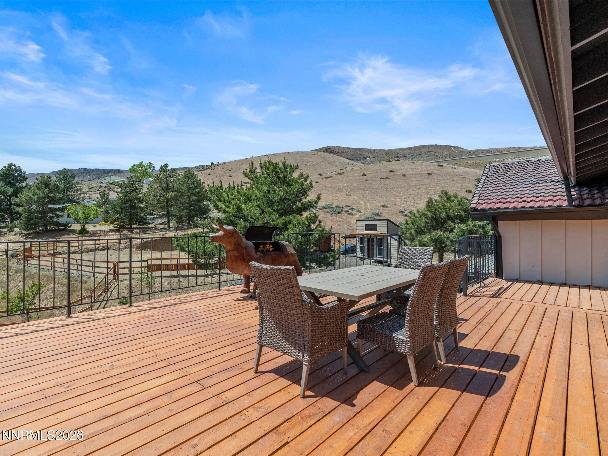 20449 Temelec Way Reno, NV 89521 - Photo 47 of 65 a view of a roof deck with table and chairs a barbeque with wooden floor and fence