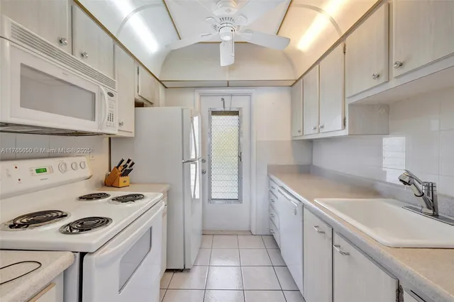 a kitchen with a stove a refrigerator and a white cabinets