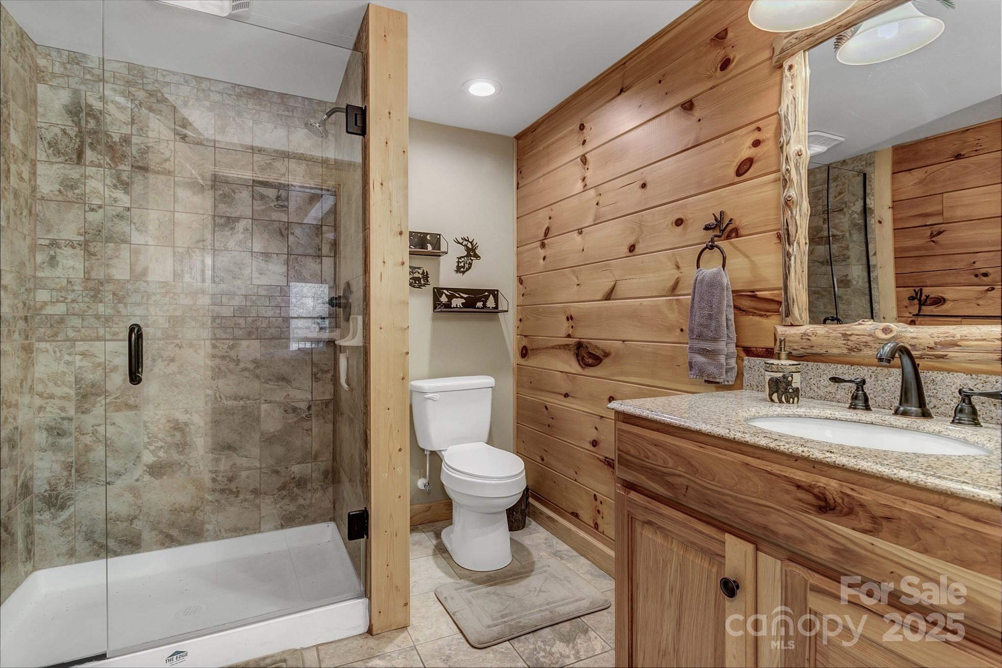 120 Sweetbriar Road North Lake Lure, NC 28746 - Photo 14 of 45 a bathroom with a granite countertop sink a toilet a mirror and shower
