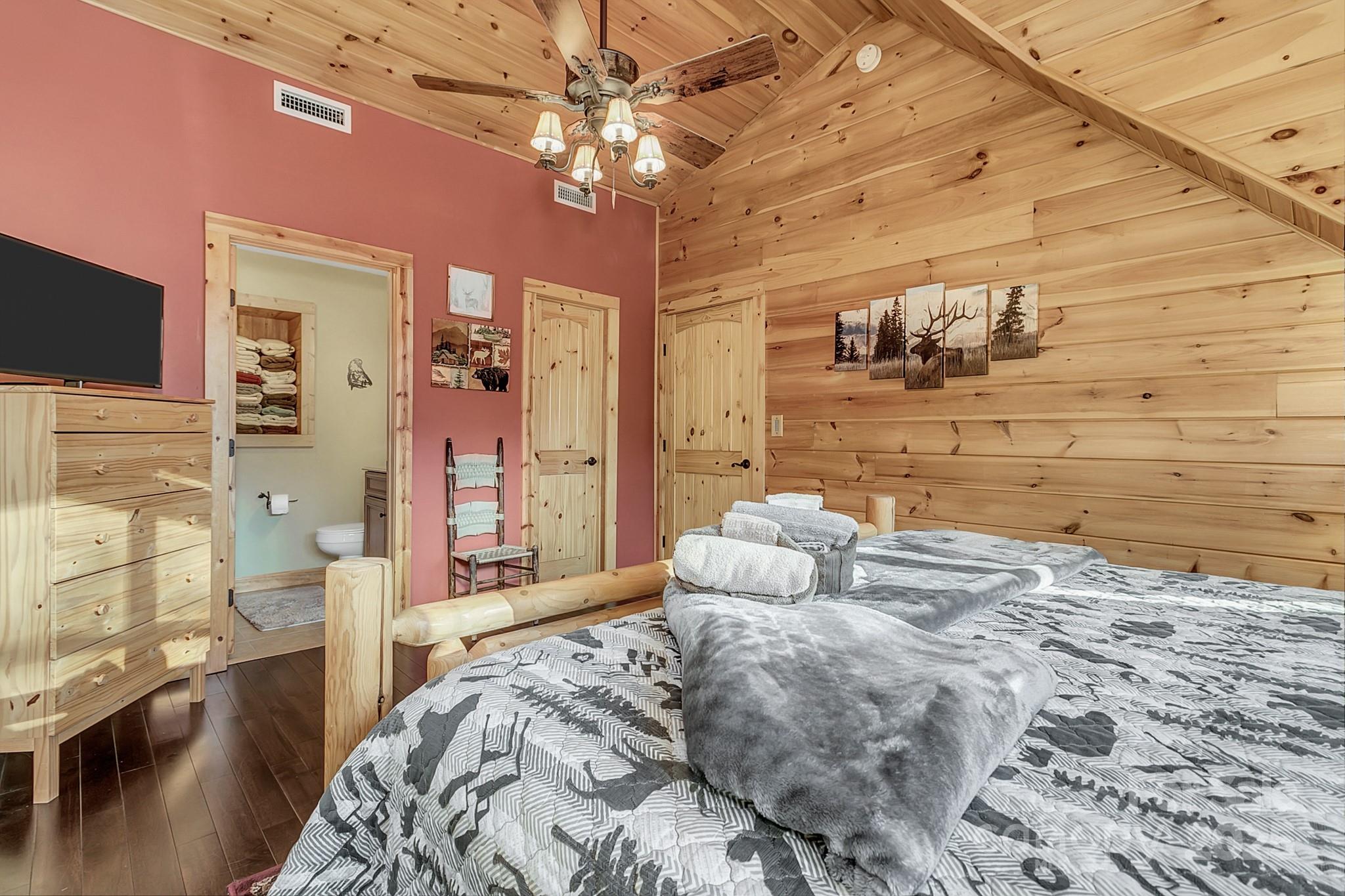 120 Sweetbriar Road North Lake Lure, NC 28746 - Photo 28 of 45 a bedroom with a bed and a chandelier