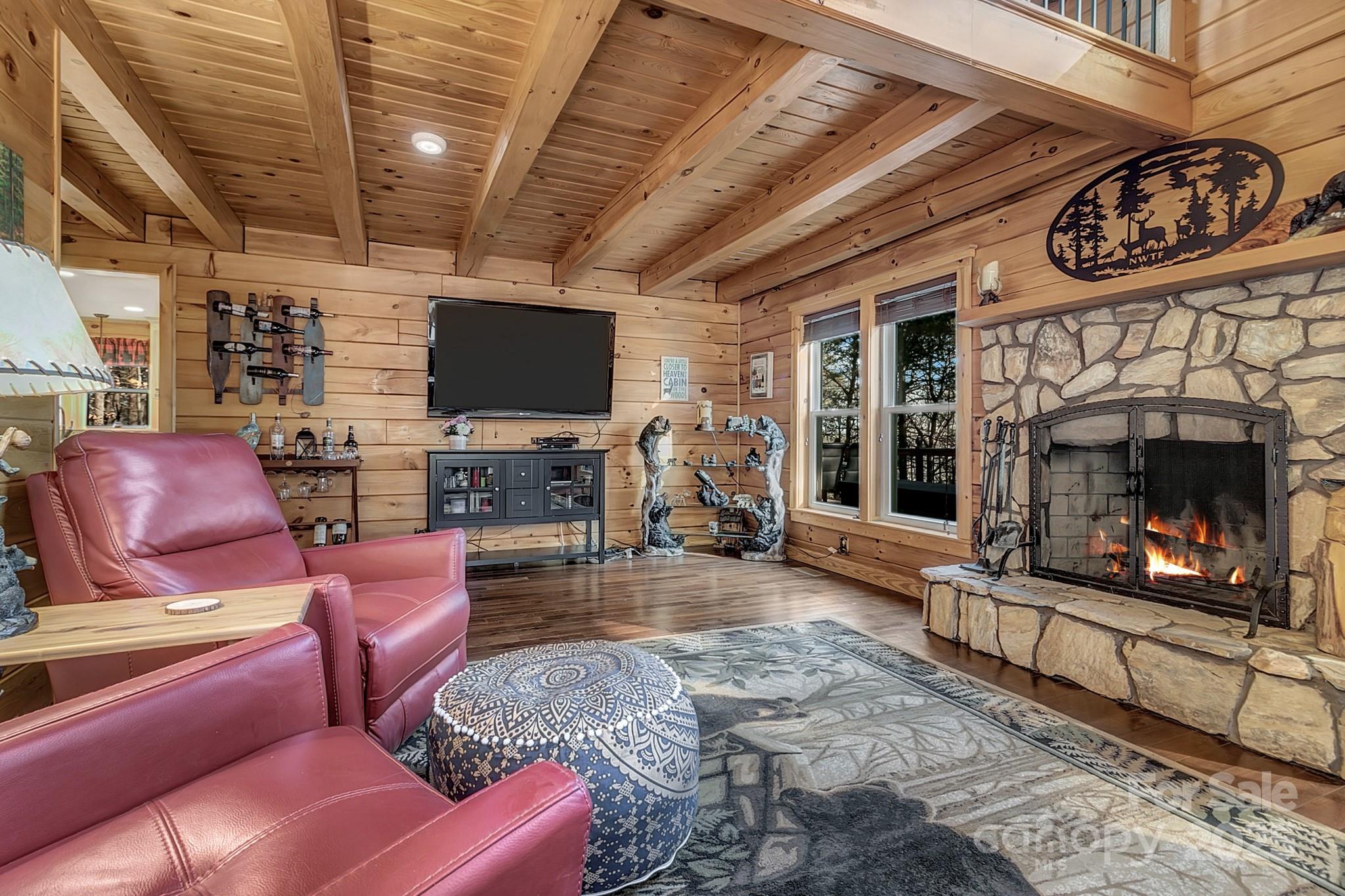 120 Sweetbriar Road North Lake Lure, NC 28746 - Photo 6 of 45 a living room with furniture a flat screen tv and a fireplace