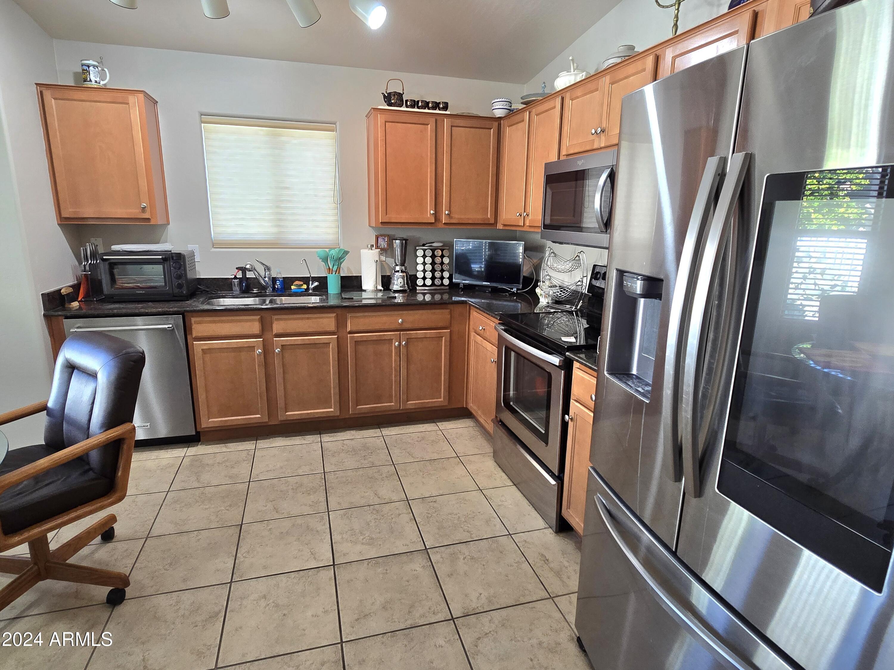 2101 South Meridian Road, Unit 274 Apache Junction, AZ 85120 - Photo 11 of 58 a kitchen with stainless steel appliances granite countertop a refrigerator stove and sink