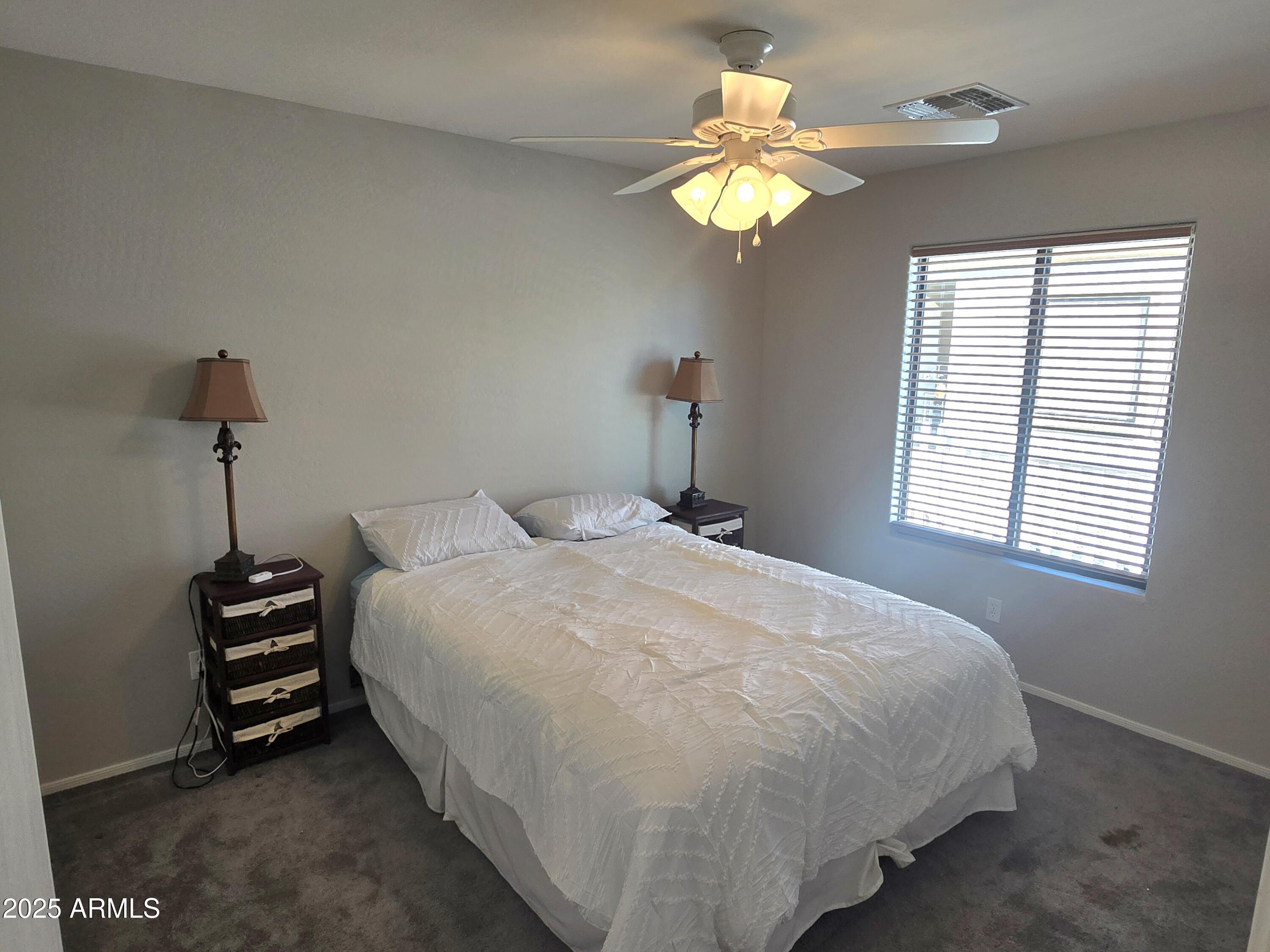 2101 South Meridian Road, Unit 274 Apache Junction, AZ 85120 - Photo 21 of 58 a bedroom with a bed and a chandelier