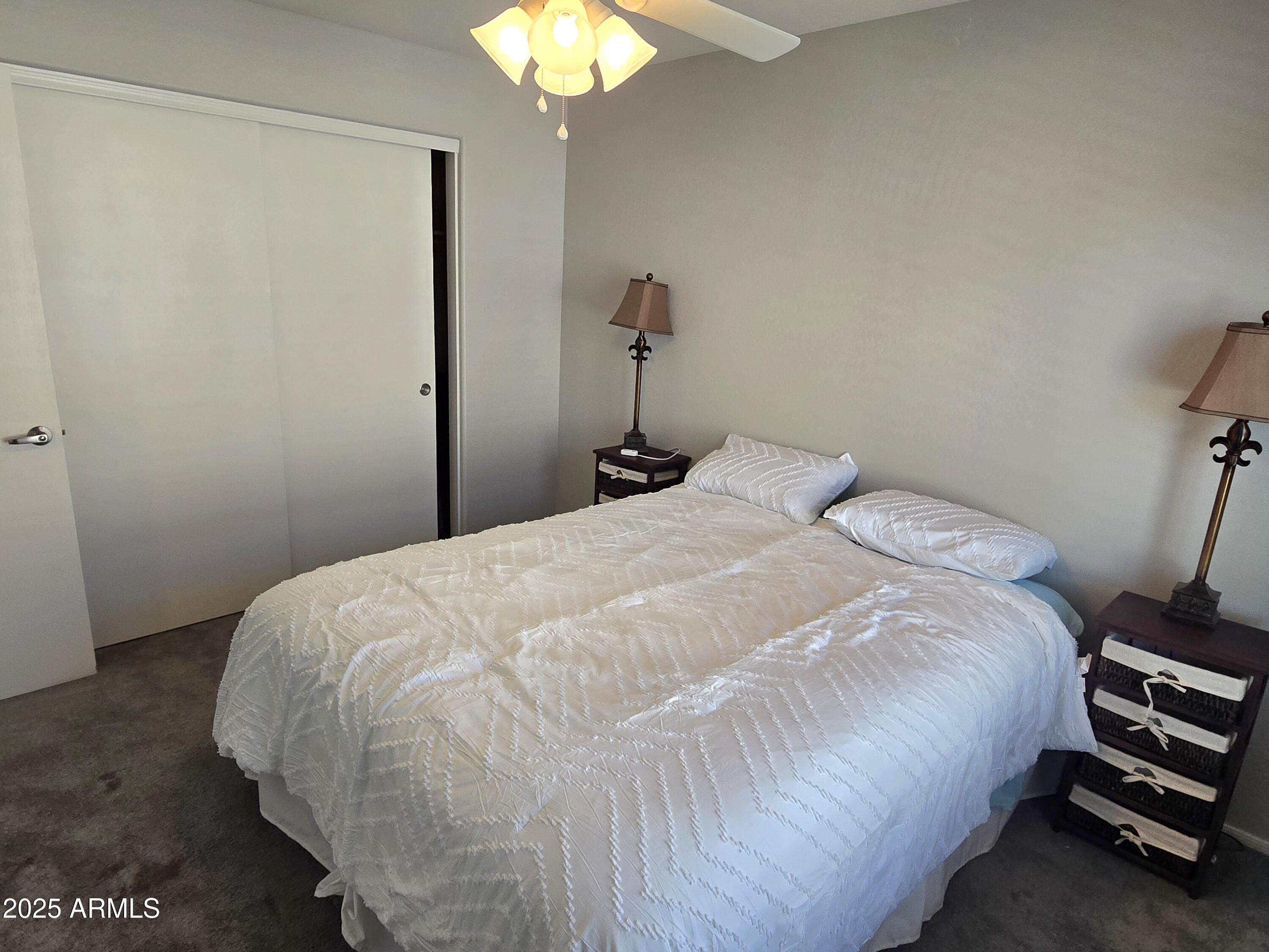 2101 South Meridian Road, Unit 274 Apache Junction, AZ 85120 - Photo 22 of 58 a bedroom with a bed and a chandelier