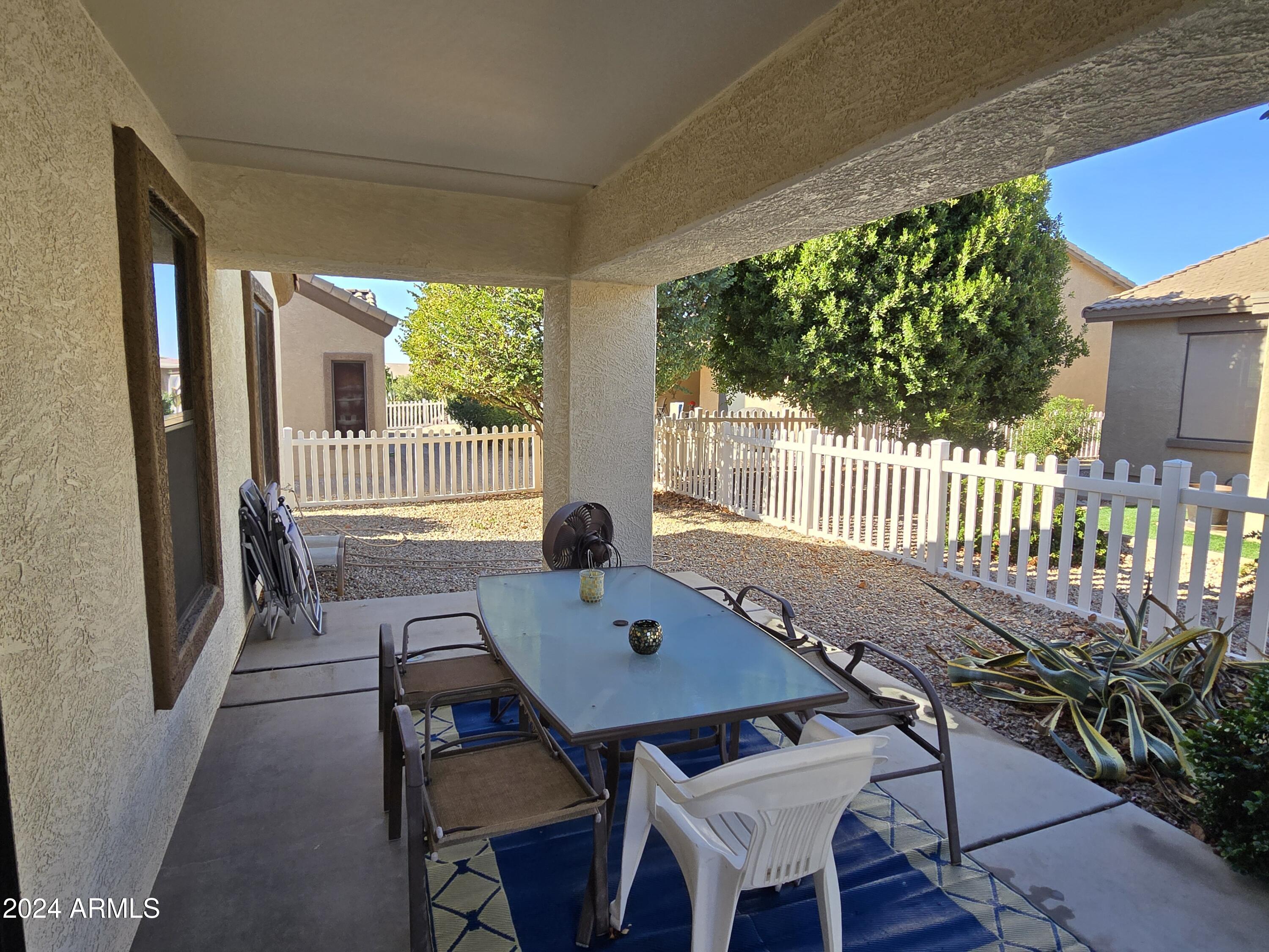 2101 South Meridian Road, Unit 274 Apache Junction, AZ 85120 - Photo 25 of 58 a view of a patio with a table chairs and a backyard