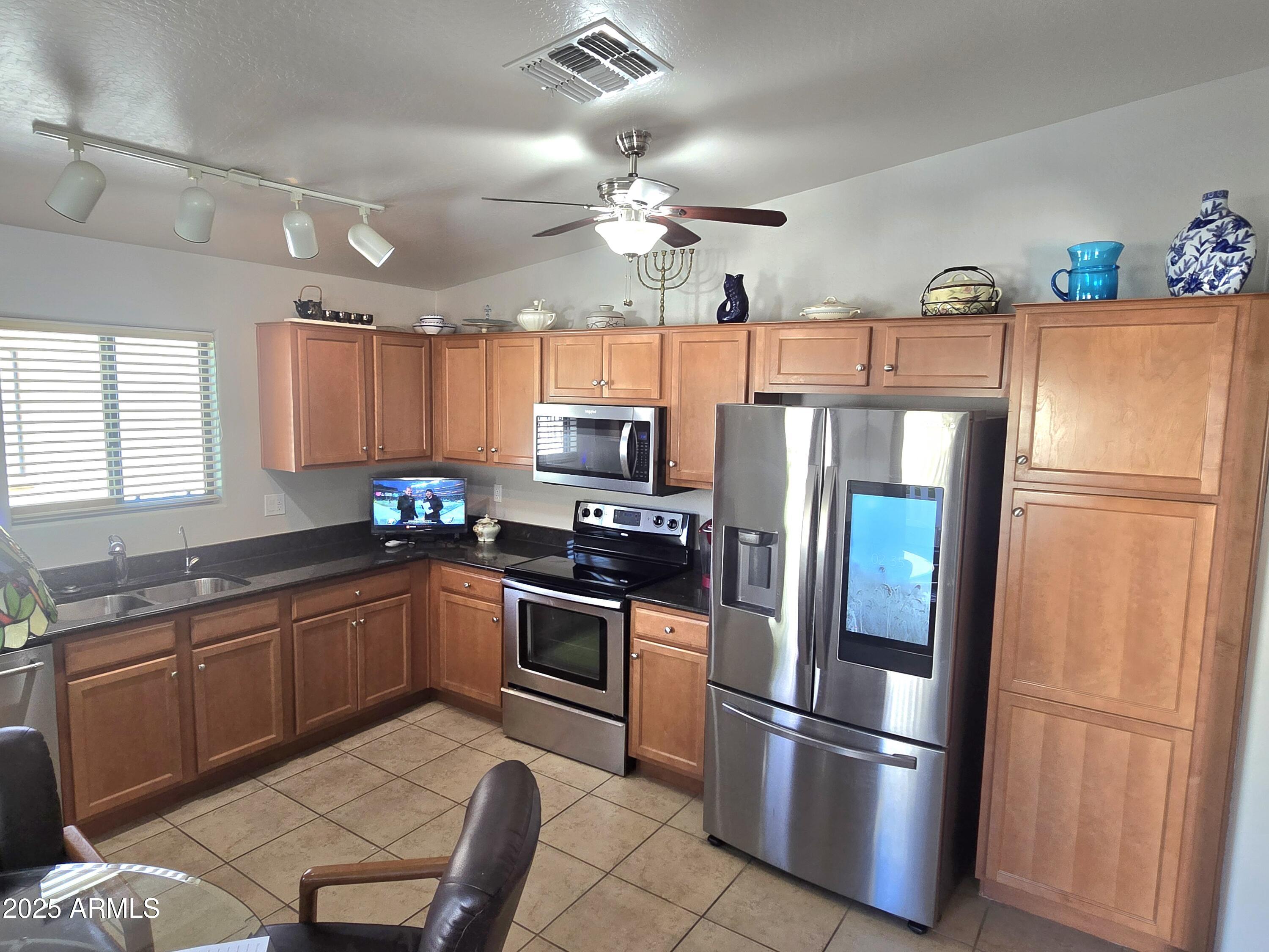 2101 South Meridian Road, Unit 274 Apache Junction, AZ 85120 - Photo 9 of 58 a kitchen with stainless steel appliances granite countertop a refrigerator a stove a sink and a refrigerator