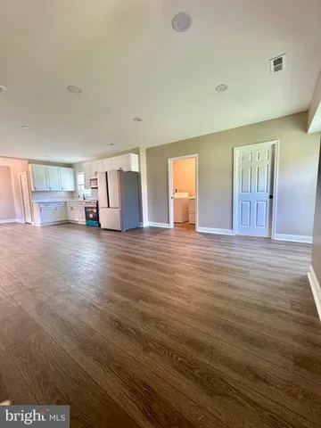 a view of empty room with wooden floor