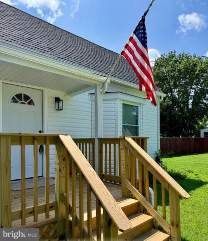 a view of deck with two large window and garden