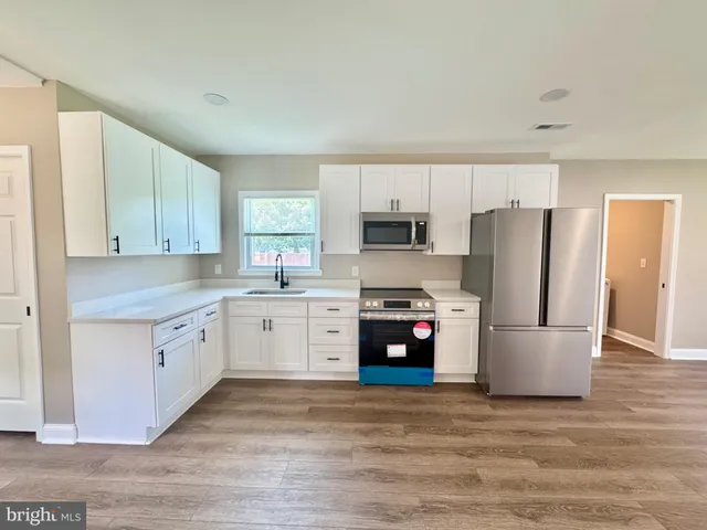 a kitchen with a refrigerator and a stove top oven