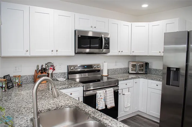 a kitchen with stainless steel appliances granite countertop a sink and a stove
