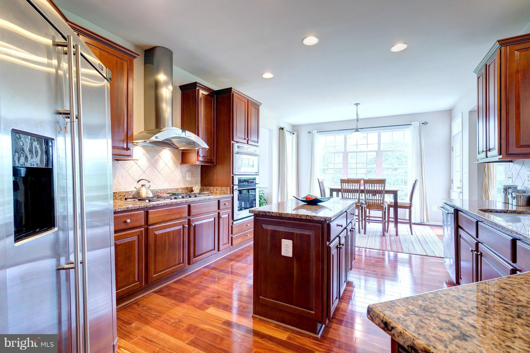 2014 Myrtlewood Road Baltimore, MD 21209 - Photo 11 of 30 a kitchen with stainless steel appliances granite countertop a refrigerator a stove top oven and a dining table with wooden floor