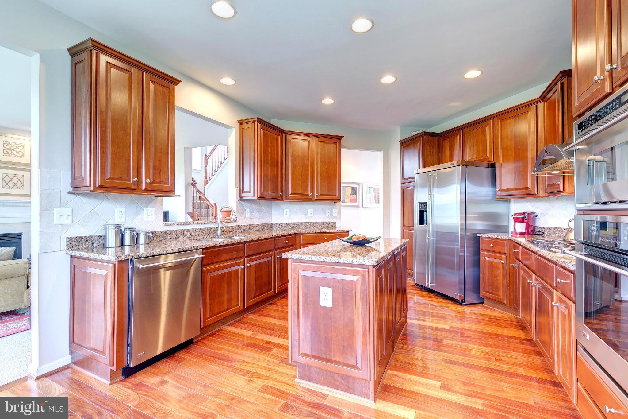 2014 Myrtlewood Road Baltimore, MD 21209 - Photo 9 of 30 a kitchen with stainless steel appliances granite countertop wooden cabinets a sink a stove a refrigerator and island with wooden floors