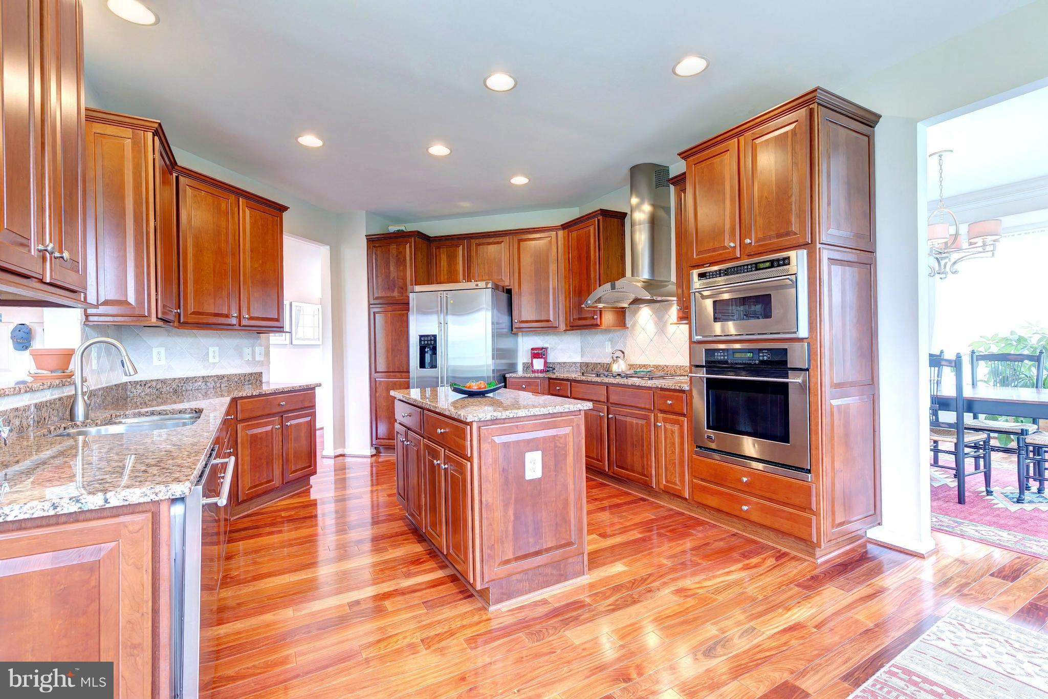2014 Myrtlewood Road Baltimore, MD 21209 - Photo 10 of 30 a kitchen with stainless steel appliances granite countertop a stove top oven a sink dishwasher a refrigerator and cabinets with wooden floor