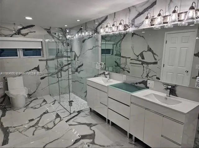 a bathroom with a double vanity sink mirror and bathtub