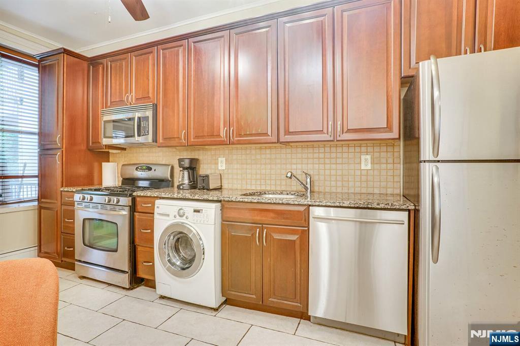 608 Madison Street, Unit 2 Hoboken, NJ 07030 - Photo 2 of 24 a kitchen with stainless steel appliances granite countertop a refrigerator a washer and dryer