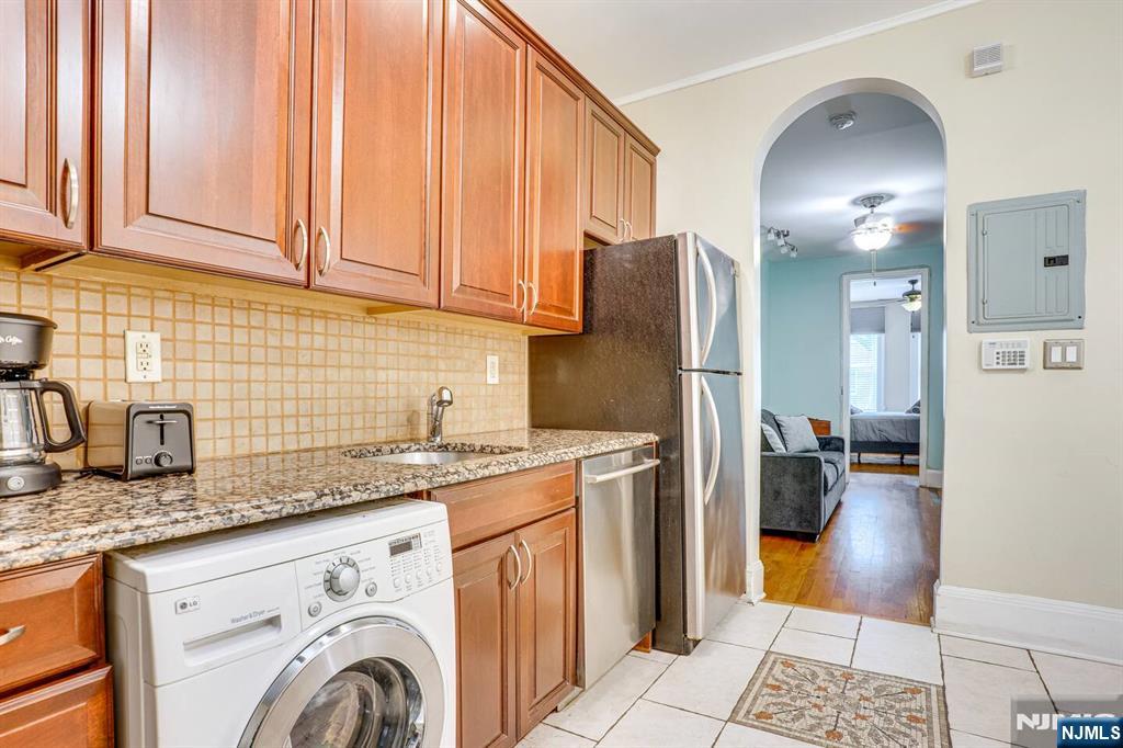 608 Madison Street, Unit 2 Hoboken, NJ 07030 - Photo 3 of 24 a kitchen with stainless steel appliances granite countertop a sink refrigerator and cabinets