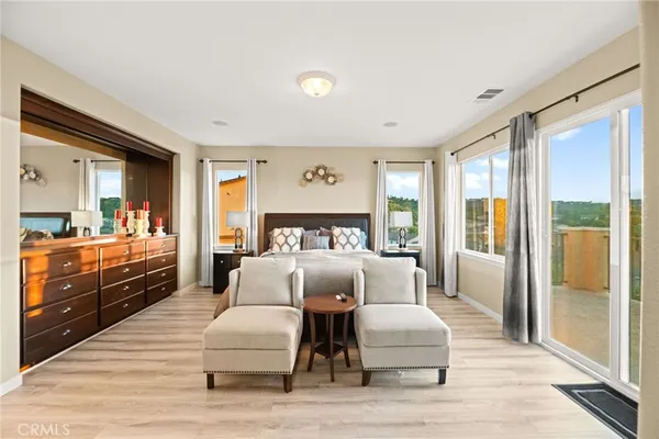 a bedroom with a large bed and a wooden floor