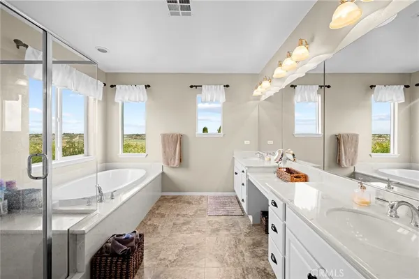 a spacious bathroom with a double vanity sink a mirror and a bathtub