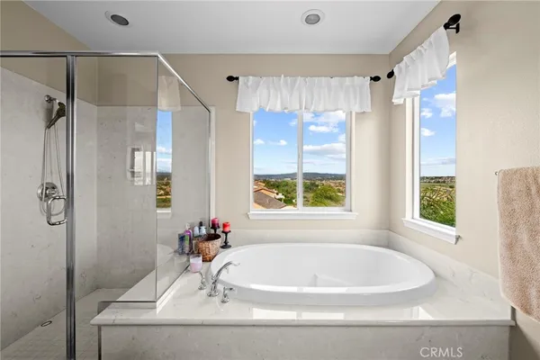 a white bath tub sitting in a bathroom next to a window