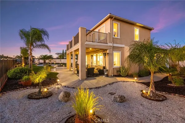 a view of a house with backyard water fountain and sitting area