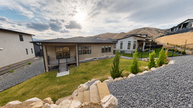 5502 North Valley View Road Lehi, UT 84048 - Photo 32 of 33 Rear exterior featuring a covered patio with metal railings, a manicured lawn, and a stone staircase