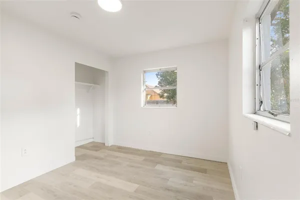 an empty room with windows and cabinet