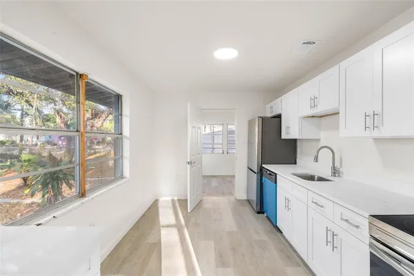 a kitchen with stainless steel appliances granite countertop a sink stove and refrigerator