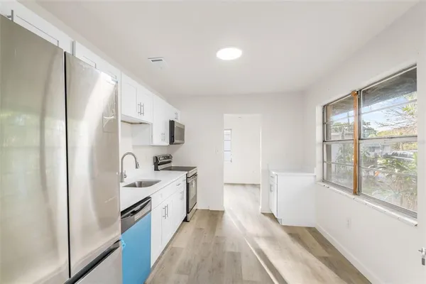 a kitchen with white cabinets and white appliances