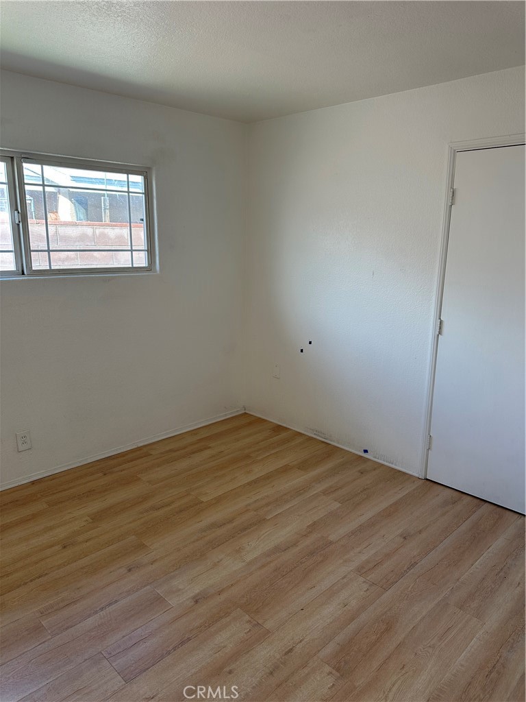 1380 Indian Sage Road Lancaster, CA 93534 - Photo 11 of 24 an empty room with wooden floor and windows