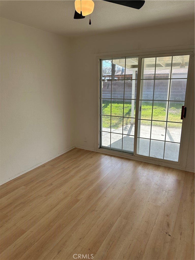 1380 Indian Sage Road Lancaster, CA 93534 - Photo 14 of 24 an empty room with wooden floor and windows