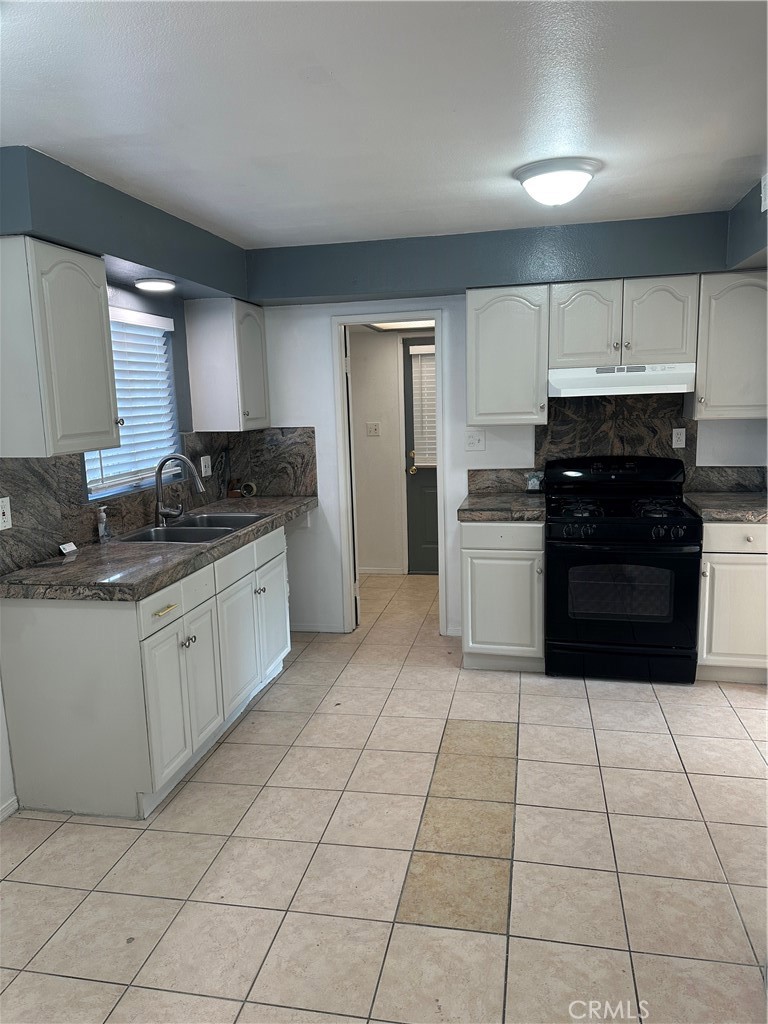 1380 Indian Sage Road Lancaster, CA 93534 - Photo 23 of 24 a kitchen with a stove top oven sink and cabinets