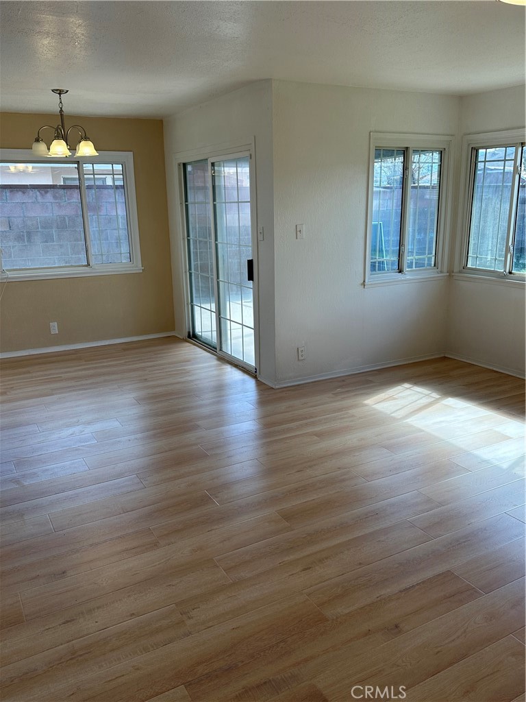 1380 Indian Sage Road Lancaster, CA 93534 - Photo 5 of 24 an empty room with wooden floor and windows