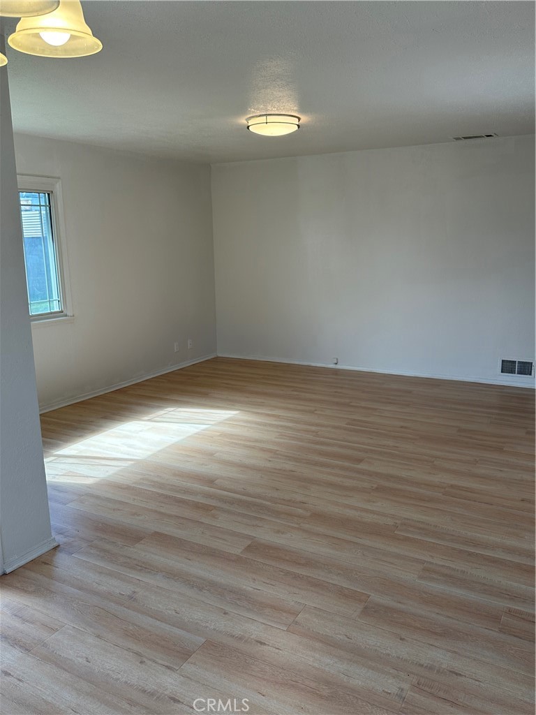 1380 Indian Sage Road Lancaster, CA 93534 - Photo 6 of 24 a view of an empty room with wooden floor and a window