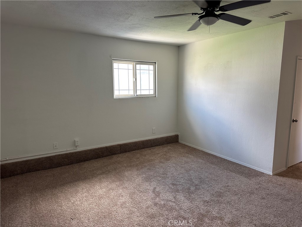 1380 Indian Sage Road Lancaster, CA 93534 - Photo 8 of 24 an empty room with a window and a fan