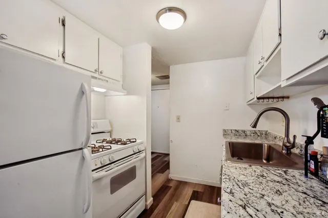 a kitchen with a table chairs refrigerator and cabinets