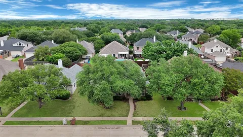 an aerial view of residential houses with outdoor space and trees