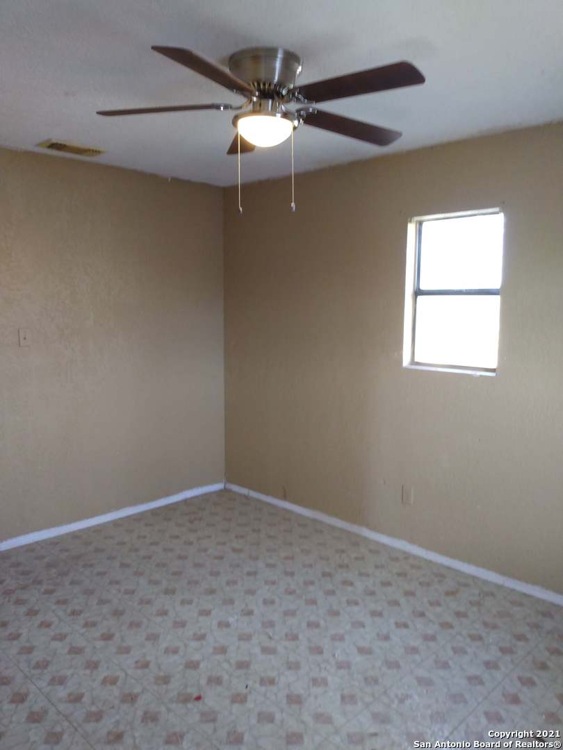 818 Austin Street Asherton, TX 78827 - Photo 8 of 15 an empty room with a window and a fan