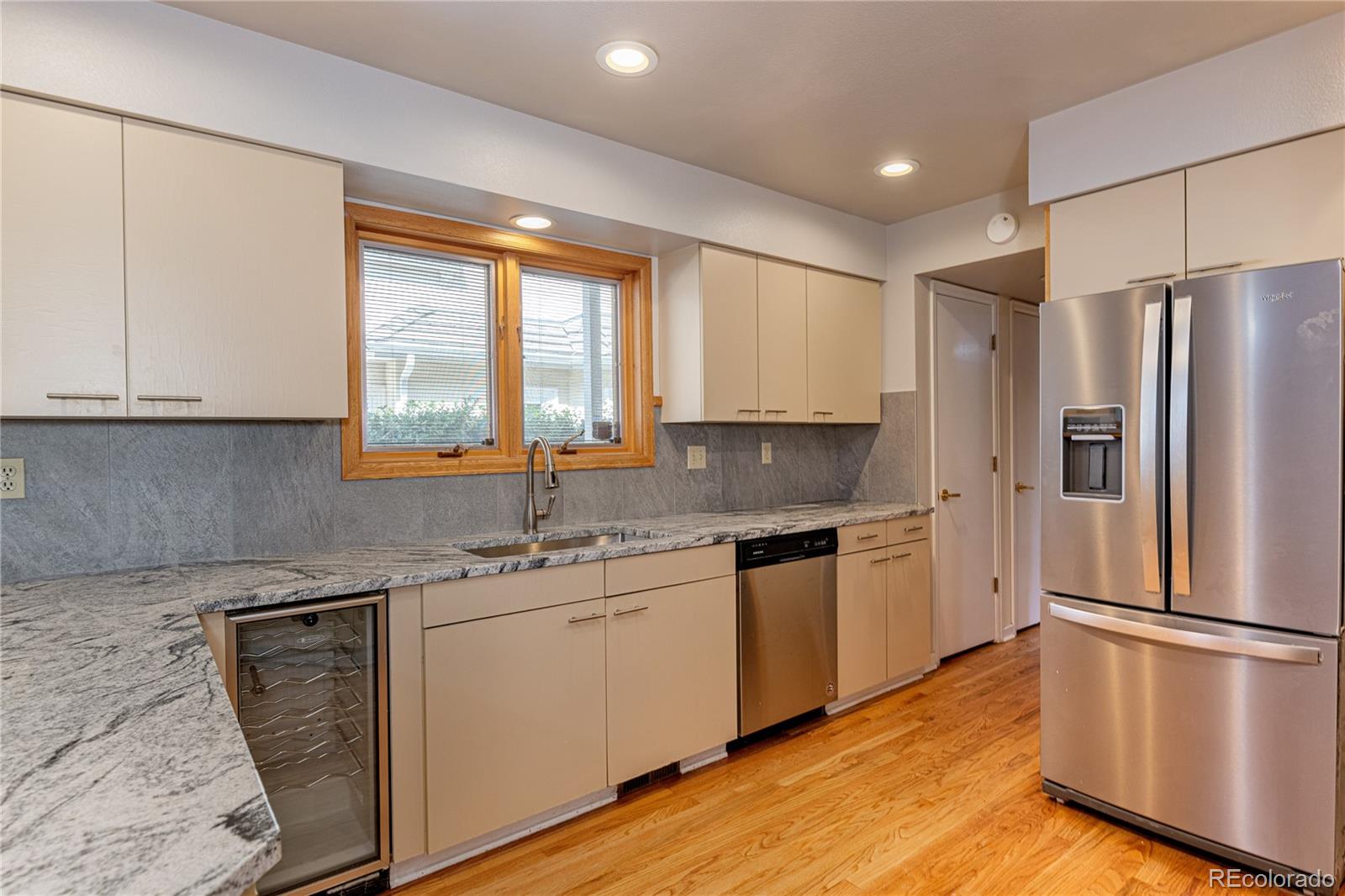 a kitchen with stainless steel appliances granite countertop a refrigerator sink and cabinets