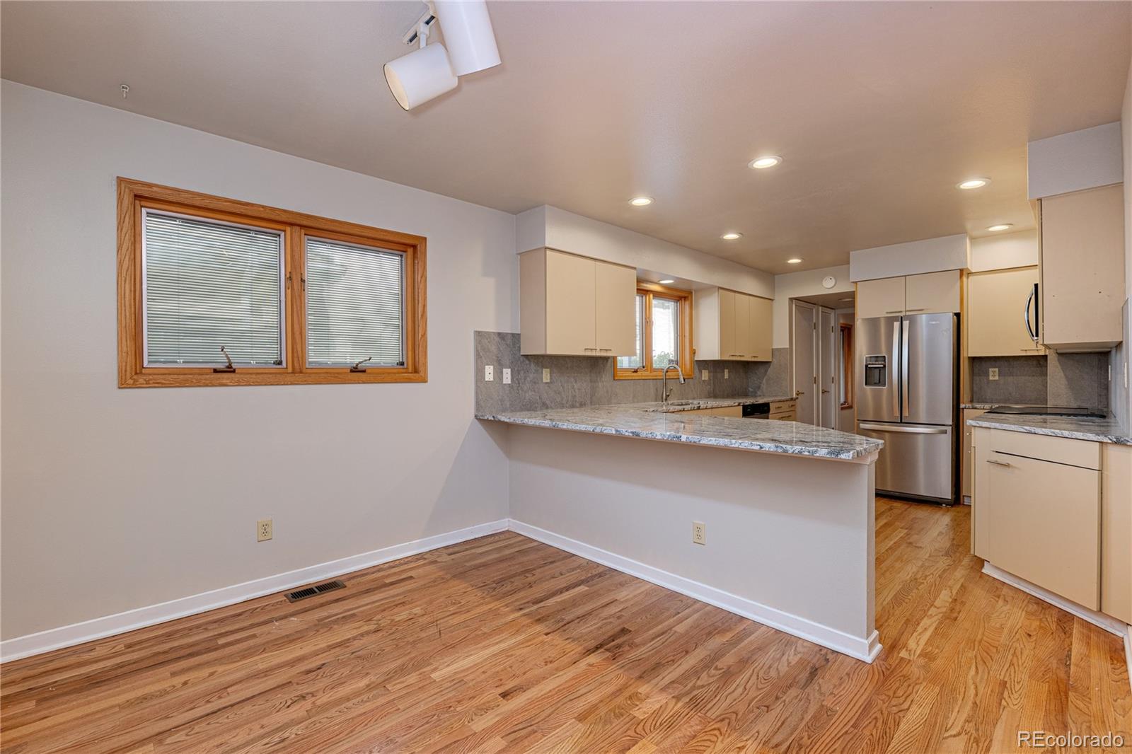 541 Monroe Street, Unit B Denver, CO 80206 - Photo 13 of 37 a kitchen with stainless steel appliances granite countertop a refrigerator a sink dishwasher a stove and white countertops with wooden floor