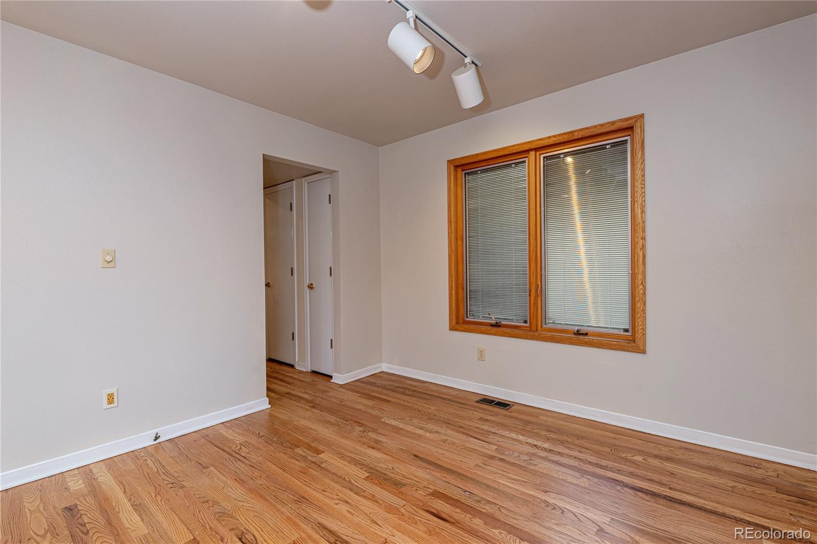 541 Monroe Street, Unit B Denver, CO 80206 - Photo 18 of 37 a view of an empty room with wooden floor and a window