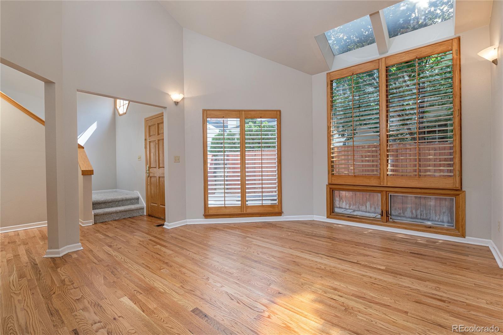 541 Monroe Street, Unit B Denver, CO 80206 - Photo 5 of 37 a view of an empty room with wooden floor and a window
