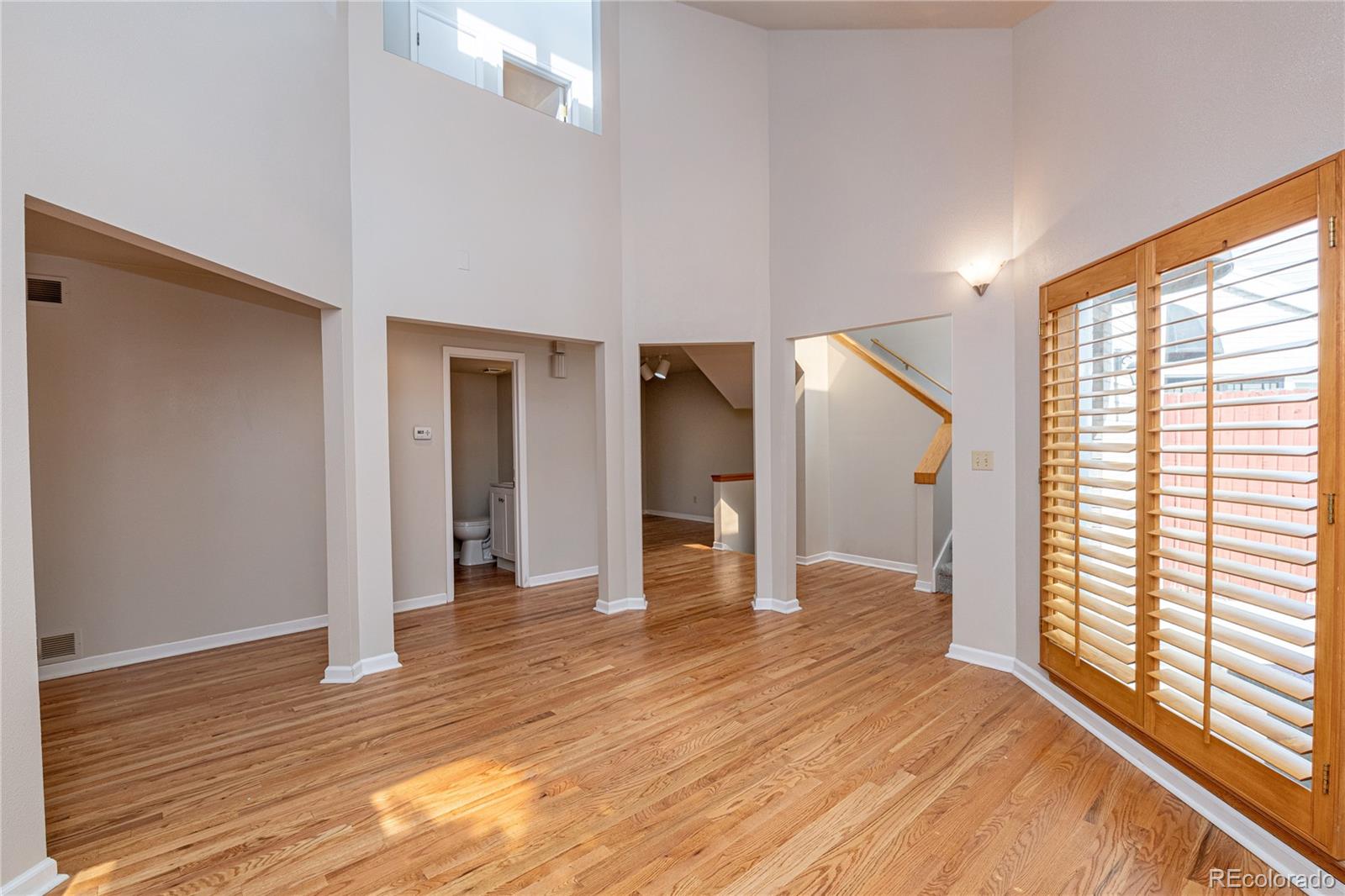541 Monroe Street, Unit B Denver, CO 80206 - Photo 6 of 37 a view of an empty room with wooden floor and a window