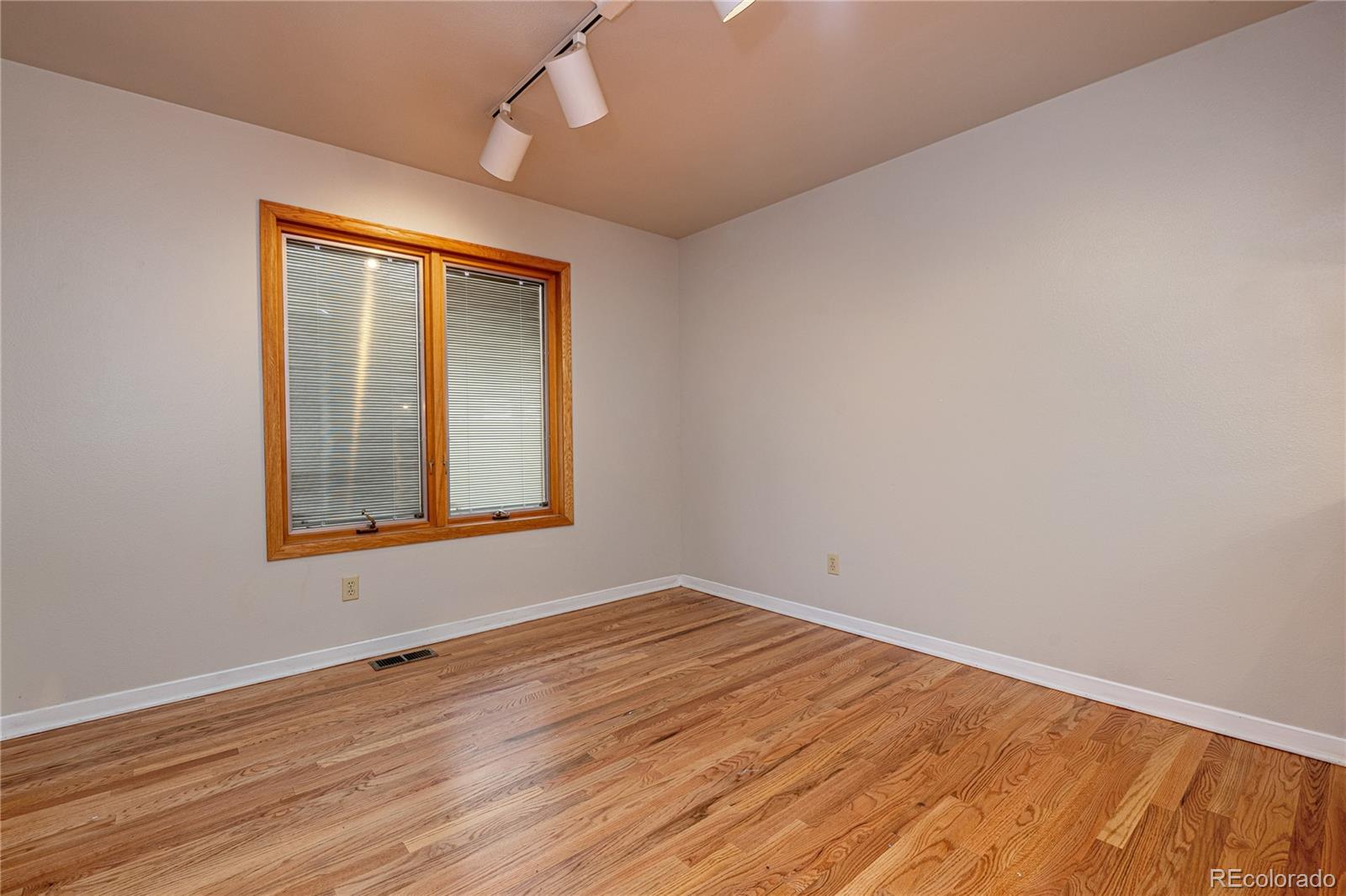 541 Monroe Street, Unit B Denver, CO 80206 - Photo 8 of 37 a view of an empty room with wooden floor and a window