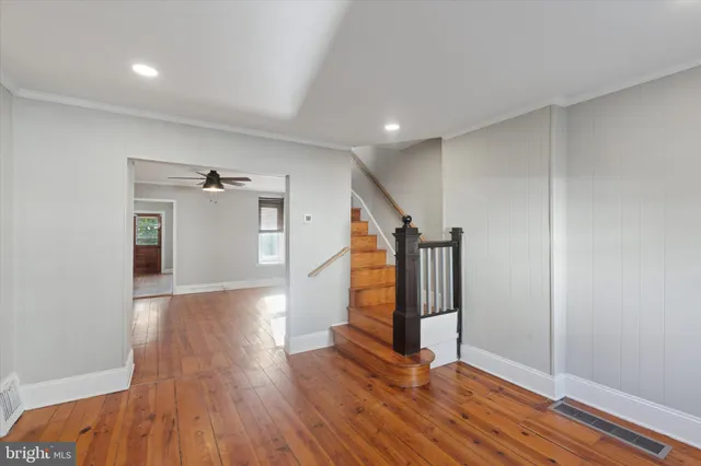 a view of a hallway with wooden floor and staircase
