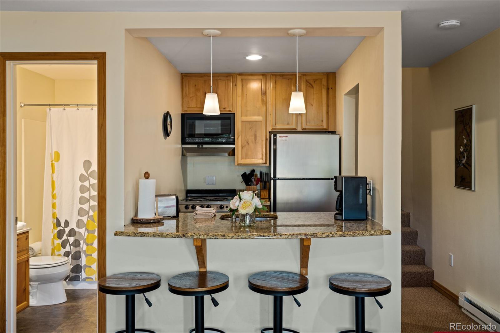 1800 Burgess Creek Road, Unit 205 Steamboat Springs, CO 80487 - Photo 14 of 28 a kitchen with stainless steel appliances a sink and a refrigerator