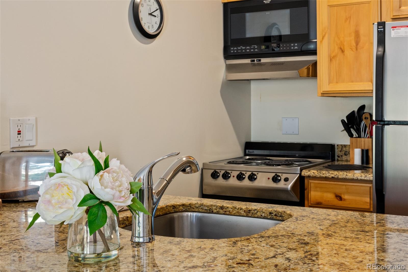 1800 Burgess Creek Road, Unit 205 Steamboat Springs, CO 80487 - Photo 15 of 28 a kitchen with stainless steel appliances granite countertop a stove a sink and a microwave