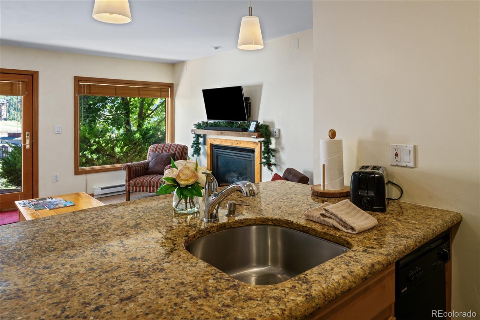 1800 Burgess Creek Road, Unit 205 Steamboat Springs, CO 80487 - Photo 17 of 28 a kitchen with a stove a sink and a dining table with garden view