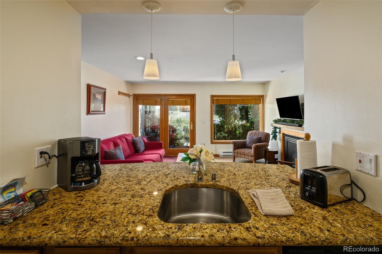 1800 Burgess Creek Road, Unit 205 Steamboat Springs, CO 80487 - Photo 18 of 28 a living room with fireplace furniture and a flat screen tv