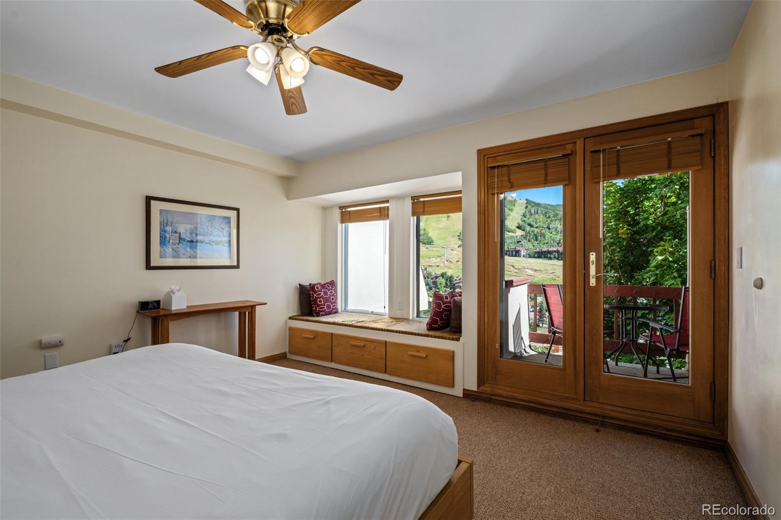 1800 Burgess Creek Road, Unit 205 Steamboat Springs, CO 80487 - Photo 21 of 28 a bedroom with a large bed and a chandelier