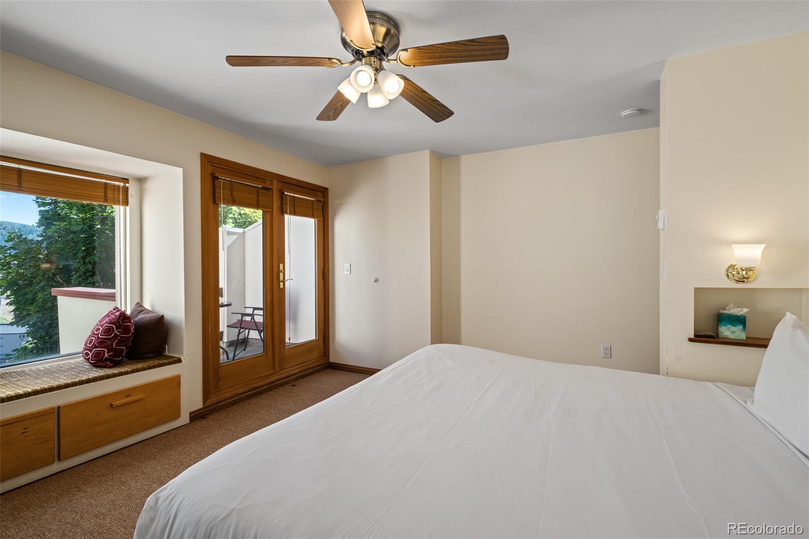 1800 Burgess Creek Road, Unit 205 Steamboat Springs, CO 80487 - Photo 24 of 28 a bedroom with a bed and large windows